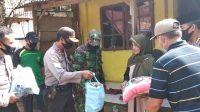 Personel Polisi saat bagikan sembako kepada warga
