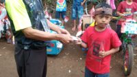 Ketua Rt05/07 Cipicung saat memberikan hadiah pada pemenang karnapal sepeda hias.